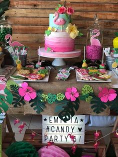 a table topped with pink and green cake next to a sign that says emo la candy party 5