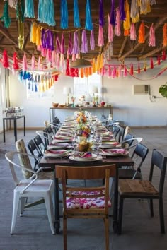 a long table is set with colorful tassels hanging from the ceiling