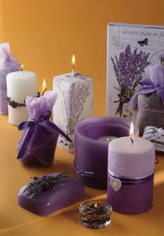 lavender candles are arranged on a table next to a greeting card and two small bags