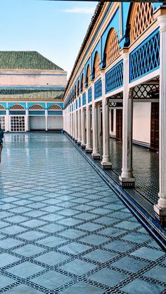 a person walking down a walkway with an umbrella in the rain and tiled flooring