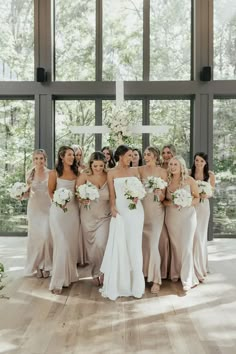 a group of women standing next to each other in front of a cross with flowers