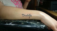 a person with a tattoo on their arm that says dictas and is sitting in front of a desk