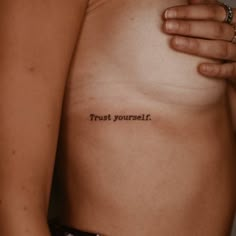 a woman's chest with the words trust yourself tattooed on it