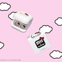 two hello kitty erasers sitting on top of a pink background with white clouds above them