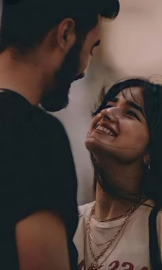 a man standing next to a woman with her face close to the camera and smiling