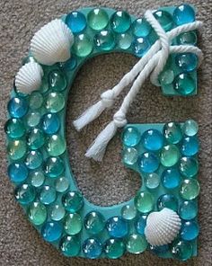 the letter e is made out of glass beads and seashells