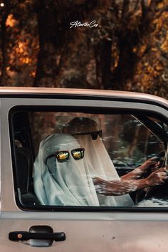 a person in a car with yellow eyes driving through the woods on a sunny day