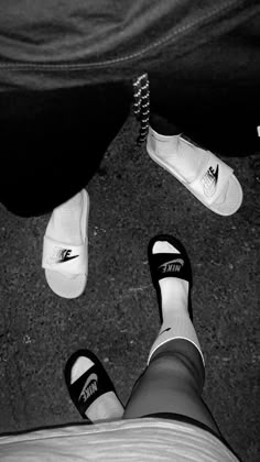 two people standing next to each other with their feet on the ground and one person wearing black and white shoes