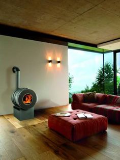 a living room filled with furniture and a fire place in the middle of it on top of a hard wood floor