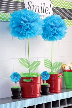 three flower pots with blue flowers in them on a shelf next to a sign that says smile