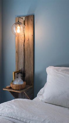 a bed with a wooden headboard and lamp on it