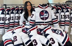 a woman standing in front of a bunch of hockey jerseys