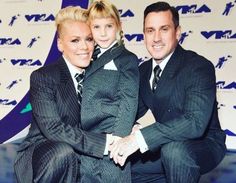 a man and woman in suits posing for a photo on the blue carpet at an awards event