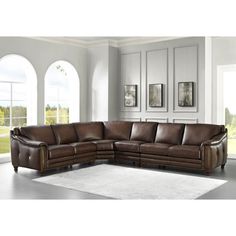 a brown leather sectional sofa sitting on top of a white rug