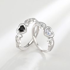 two silver rings with hearts and diamonds on them, one has a black diamond in the middle