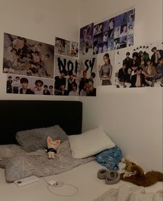 a bed room with a neatly made bed and many pictures on the wall above it