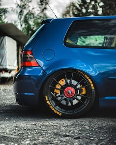 a blue car parked on top of a gravel road