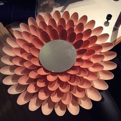 a large paper flower sitting on top of a table next to a mirror and pen