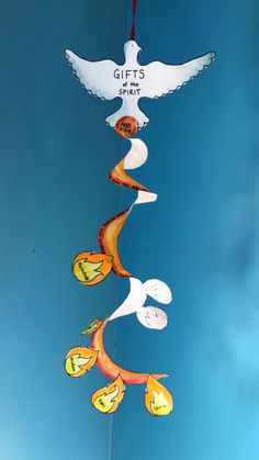 a wind chime with birds and pumpkins hanging from it's sides on a blue sky background