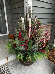 a potted plant with candy canes and greenery in front of a house