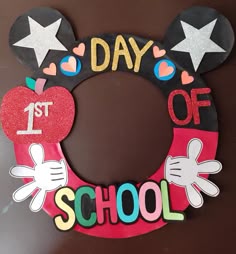 a mickey mouse wreath with the words 1st of school written on it and an apple