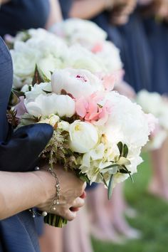 the bridesmaids are holding their bouquets with white and pink flowers on them