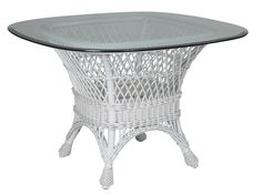 a white wicker table with glass top