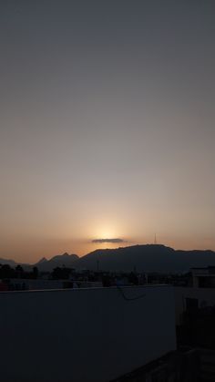 the sun is setting over some mountains in the distance