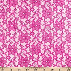 pink lace fabric with flowers and leaves on the side, as well as a ruler