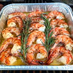 cooked shrimp with rosemary garnish in an oven