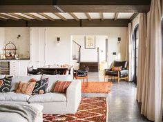 a living room filled with furniture and lots of windows