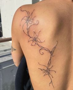 the back of a woman's shoulder with flowers on it