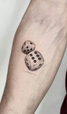 two dice tattoo on the arm