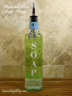 a green bottle with the word soap on it sitting on a counter top next to a tile wall