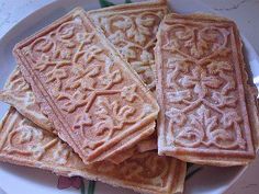 four waffles on a white plate with green stems