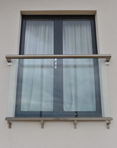 a cat sitting on the ledge of a window