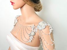 a mannequin wearing a white dress with beading and pearls on it's shoulders