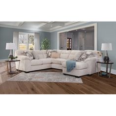 a large sectional couch in a living room with hardwood floors and blue walls on the wall