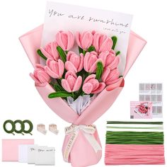 a bouquet of pink tulips is shown with ribbon and other items to make it pop