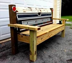 an old wooden bench sitting in front of a garage