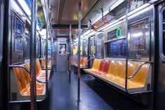 an empty subway car with orange seats