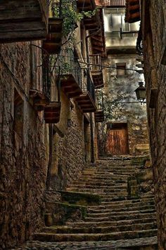 an alleyway with stone steps leading up and down