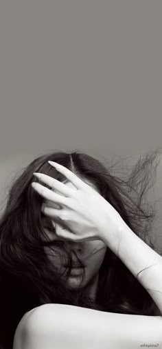 black and white photograph of a woman's head with her hands on her hair