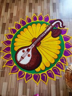 a colorful painting on the floor with a guitar