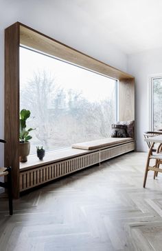 a room with a large window and wooden furniture