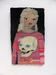 a needle - embroidered portrait of a woman with a skull on her chest, wearing a pink sweater