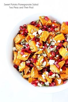 a white bowl filled with pomegranate and other food on top of a table