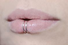 a woman's lips with two rings on her lip