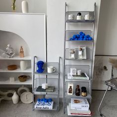 two shelves with various items on them in a living room or dining room, one shelf has blue balls and the other is white