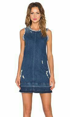 a woman wearing a denim dress with holes on it